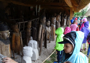 Dzieci oglądają drewniane figurki.